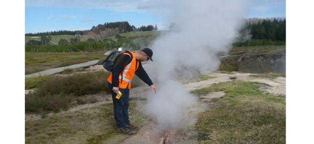 Worker next to steam vent in ground