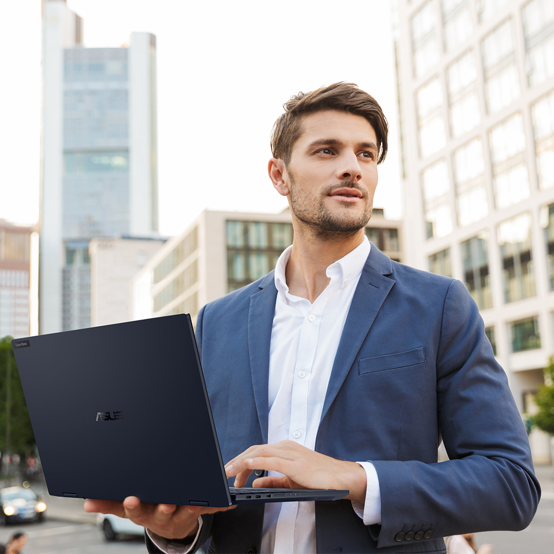 Biznesmen używa laptopa ASUS ExpertBook w podróży.