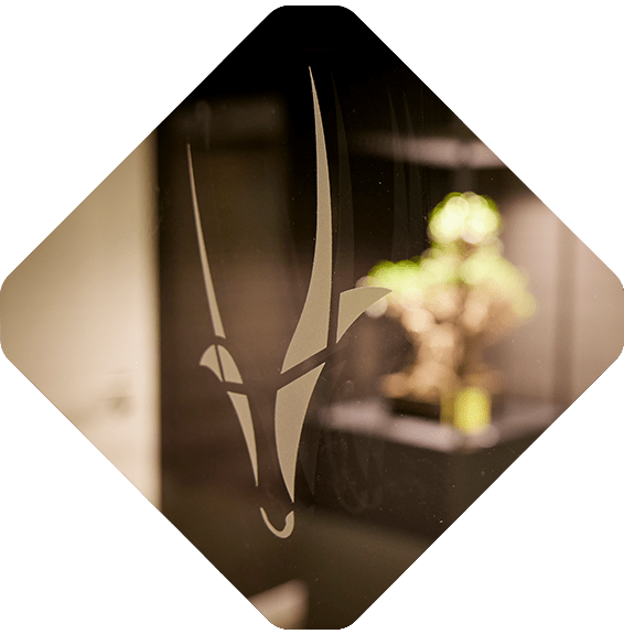 A stylized antelope head etched on a glass surface, with a small, blurred plant in the background, mirrors the innovative spirit celebrated within Spryker careers.