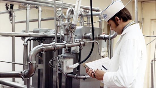 Ecolab technician from the 1970s reviewing equipment documentation