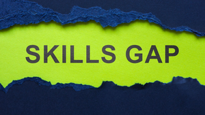 SKILLS GAP written on green paper underneath torn blue paper