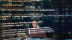 blurred programmer behind screen of code