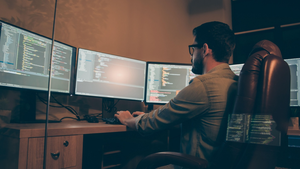 developer using multiple screens to write code