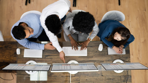 4 IT team members collaborating at a workstation