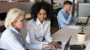 employees of different ages working together at a workstation