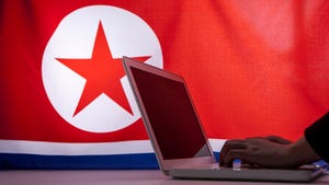 A laptop in front of a DPRK flag