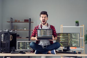 burned out worker on desk with laptop and wires 