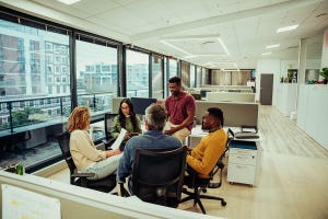 Diverse business team sitting in open office brainstorming ideas for upcoming project