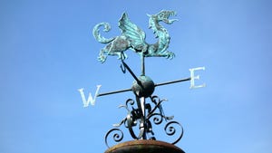 Old weather vane with dragon shape and blue sky