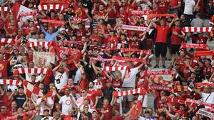 A crowd of Liverpool football fans in the stands at a game