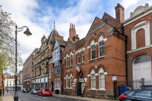 Victorian buildings, cars, and streetlights on Bishop Street in Leicester, England