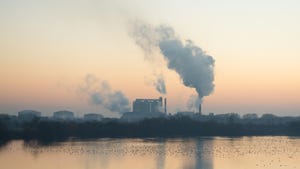 Factory with smokestacks against a dawn sky