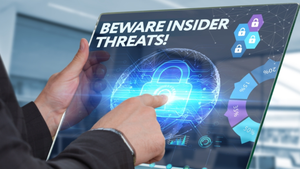 Hands of a person in a suit jacket holding a screen pointing to an image of a padlock and the words "insider threat" 