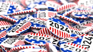 A pile of 2024 red, white, and blue, election buttons