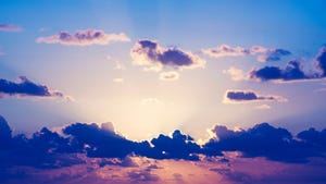 Colorful sunrise sky with clouds and the sun almost bursting out from behind them