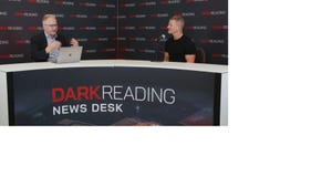 Two people talking at a news desk against a dark backdrop with "Dark Reading" written on it.