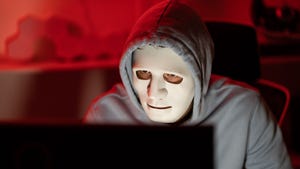 Computer hacker wearing white mask stealing data from a laptop