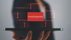 Concept illustration showing person using a tablet with virtual warning about ransomware