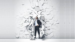 person in a dark suit and beard breaking out of a white wall