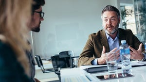 Businessman explaining new ideas to peers in office conference room.