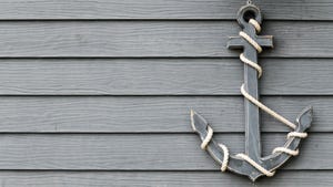 Anchor, tied with rope, on a wooden wall