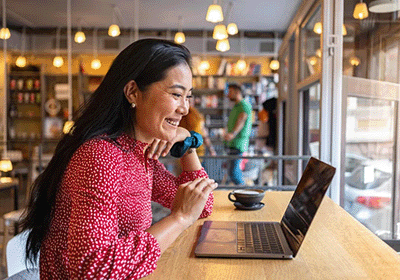 student sitting in coffee shop enjoying online class