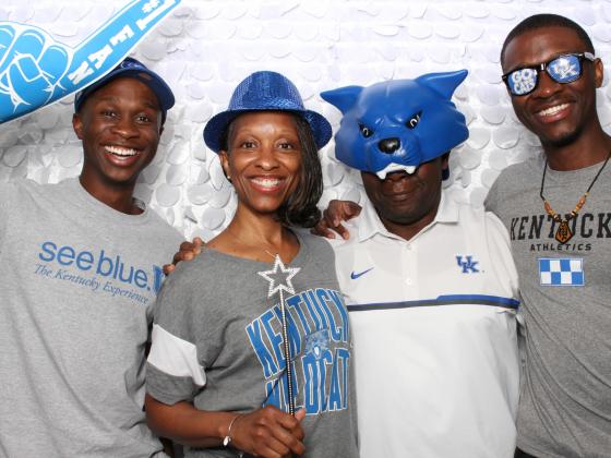 family of 4 dressed in UK branded clothing holding a foam finger and wearing hats