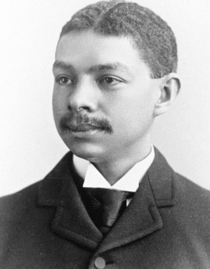 scan of black and white photo of youthful black man with mustache in a suit with collar