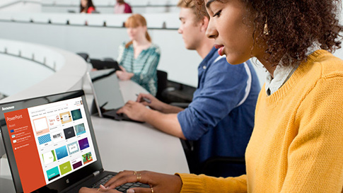 young female student working on a laptop in class.
