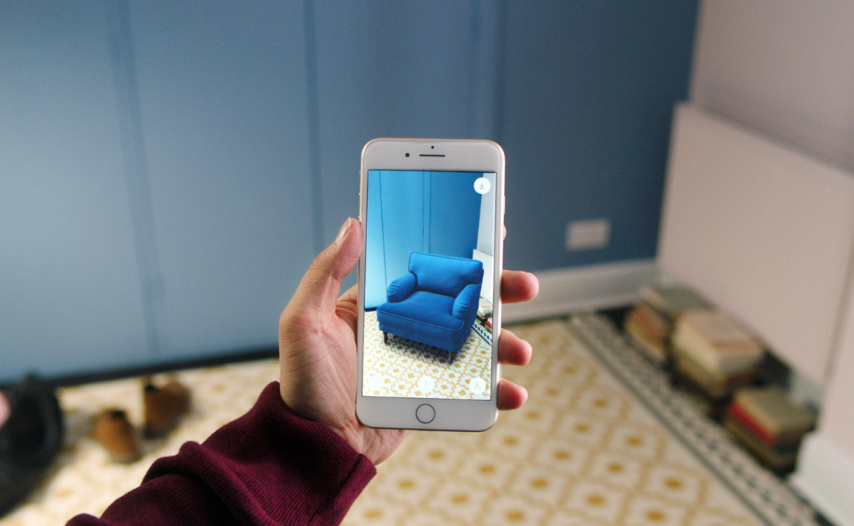 Phone showcasing a virtual couch being placed on a real world location.