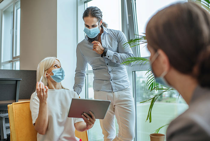 A meeting in an office with participants wearing masks