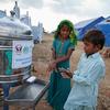 Niños desplazados se lavan las manos fuera de un baño público en un campamento en la provincia de Sindh, Pakistán.