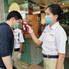 Staff check customers’ temperatures at a shopping mall entrance in Yangon, Myanmar.