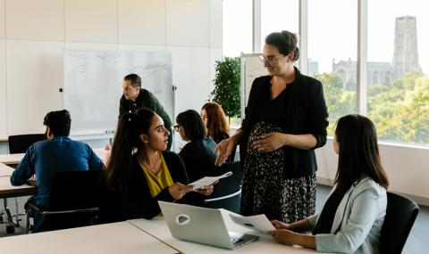 Students talking with a professor inside the classroom