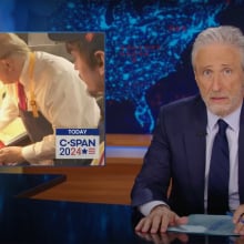 A man in a suit sits behind a talk show desk. In the top-left is a photo of a man at McDonald's.