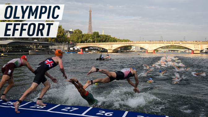 Atheletes jump in the river Seine, with Pont Neuf and the Eiffel Tower in the background. Caption reads "Olympic effort"