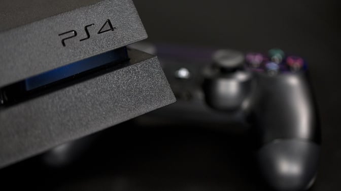 A logo sits on the front of a Sony PlayStation 4 (PS4) games console, manufactured by Sony Corp., in this arranged photograph taken in London, U.K.