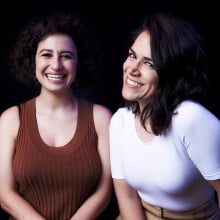 Abbi Jacobson and Ilana Glazer smiling in a portrait. 