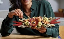 person sitting at table holding completed lego icons dried flower centerpiece