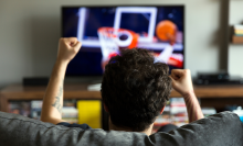 man watching basketball game from the couch