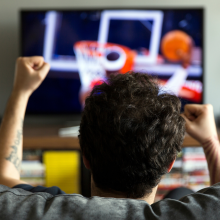 man watching basketball game from the couch