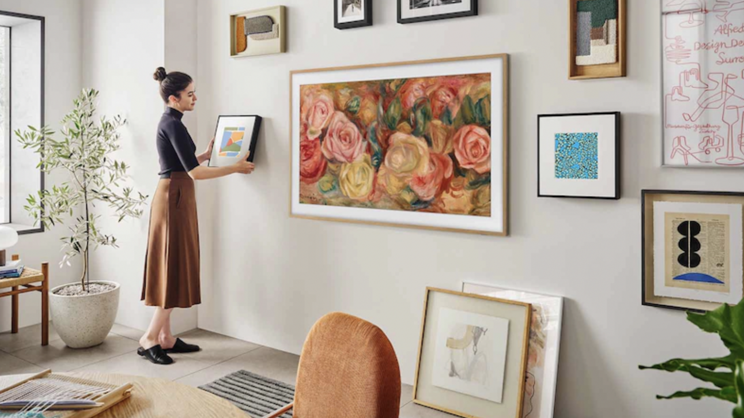 woman hanging art on wall