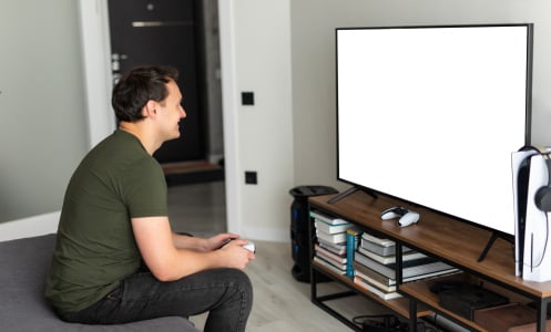 Young happy man laughing and playing video games on weekend