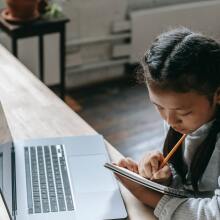 girl with braided pigtails sitting at computer