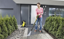 woman power washing her walkway