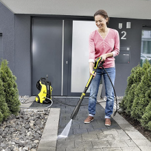 woman power washing her walkway