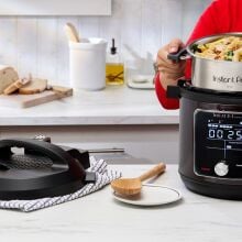 Person lifting Instant Pot inner pot with oven mitts