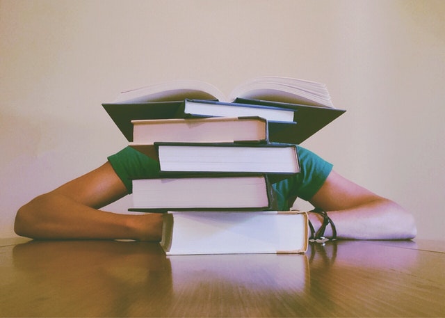 A person reading a bunch of books