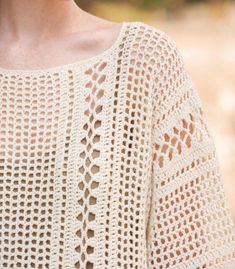 a woman wearing a white crochet sweater