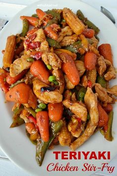 chicken stir fry with carrots and green beans on a white plate, ready to be eaten